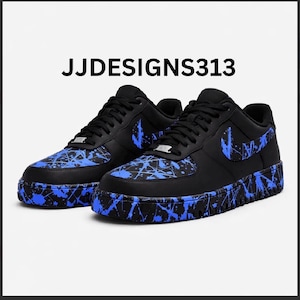 May include: Black sneakers with blue splatter paint design. The shoes feature a black Nike swoosh and the text "JJDESIGNS313". The soles and toe boxes are decorated with blue paint.