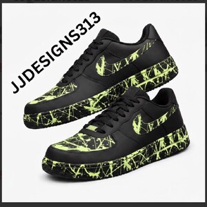 May include: Black sneakers with neon green splatter paint design. The Nike swoosh is also neon green. The text "JJDESIGNS313" is in the upper left corner. The shoes are on a white background.