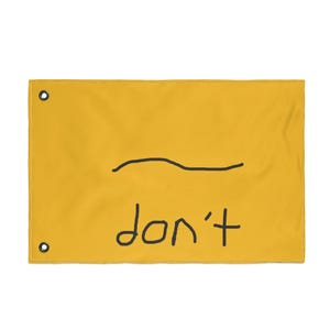 May include: A rectangular yellow banner with a black wavy line and the word "don't" written in black. The banner has a grommet in each of the top corners.