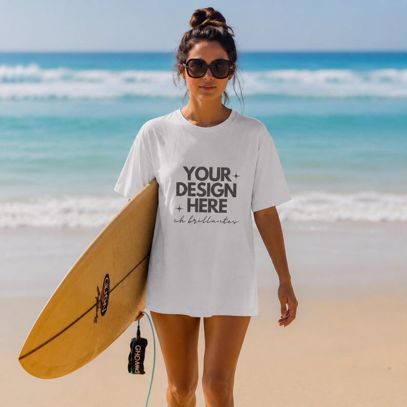 May include: A white short-sleeve t-shirt featuring the dark gray text YOUR DESIGN HERE with small star icons and the cursive script ch brillantes printed on the front. The shirt has a crew neckline and a relaxed fit, shown in a beach setting.