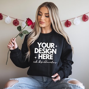 Puede incluir: Una sudadera negra con el texto "YOUR DESIGN HERE" y "ch brillantes" impreso en blanco. La sudadera está siendo modelada por una persona con cabello largo y rubio.