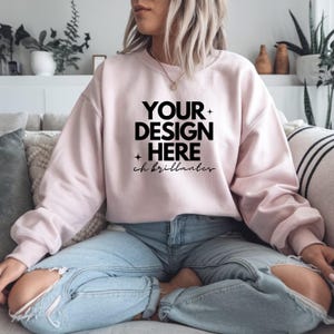 Puede incluir: Una sudadera rosa con el texto "YOUR DESIGN HERE" y "ch brillantes" en letras negras.