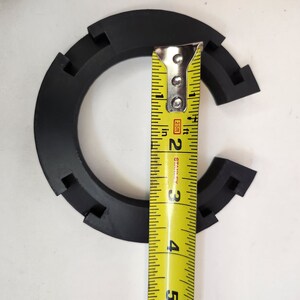 May include: A black plastic ring with a measurement tape showing a diameter of 3 inches.