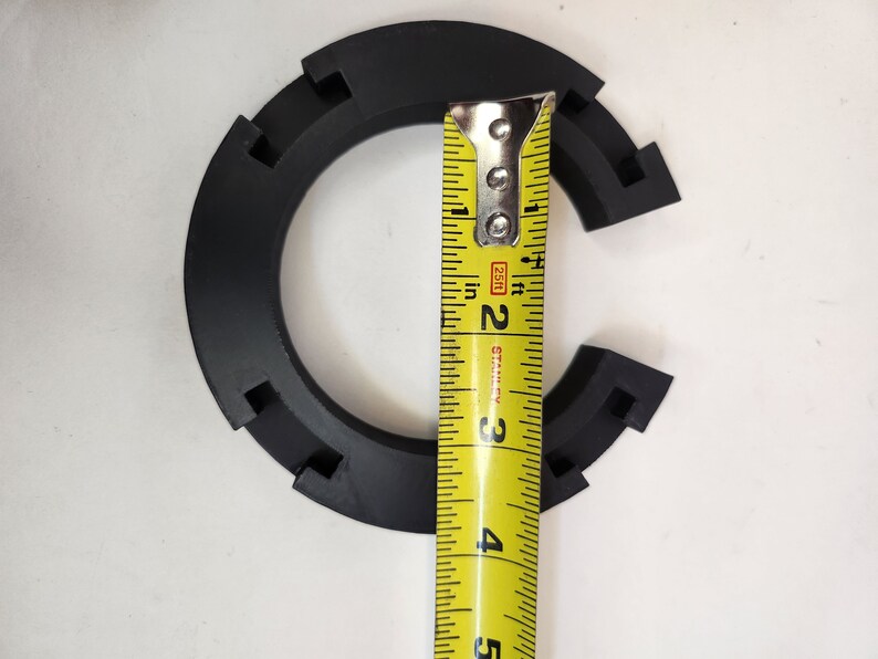 May include: A black plastic ring with a measurement tape showing a diameter of 3 inches.
