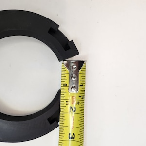 May include: A black rubber ring with a measuring tape showing a measurement of 2 inches.