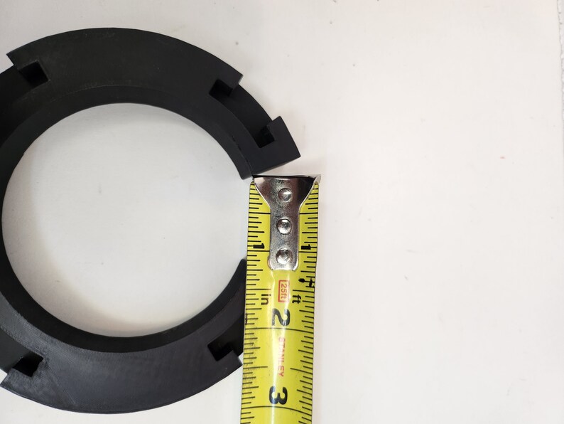 May include: A black rubber ring with a measuring tape showing a measurement of 2 inches.