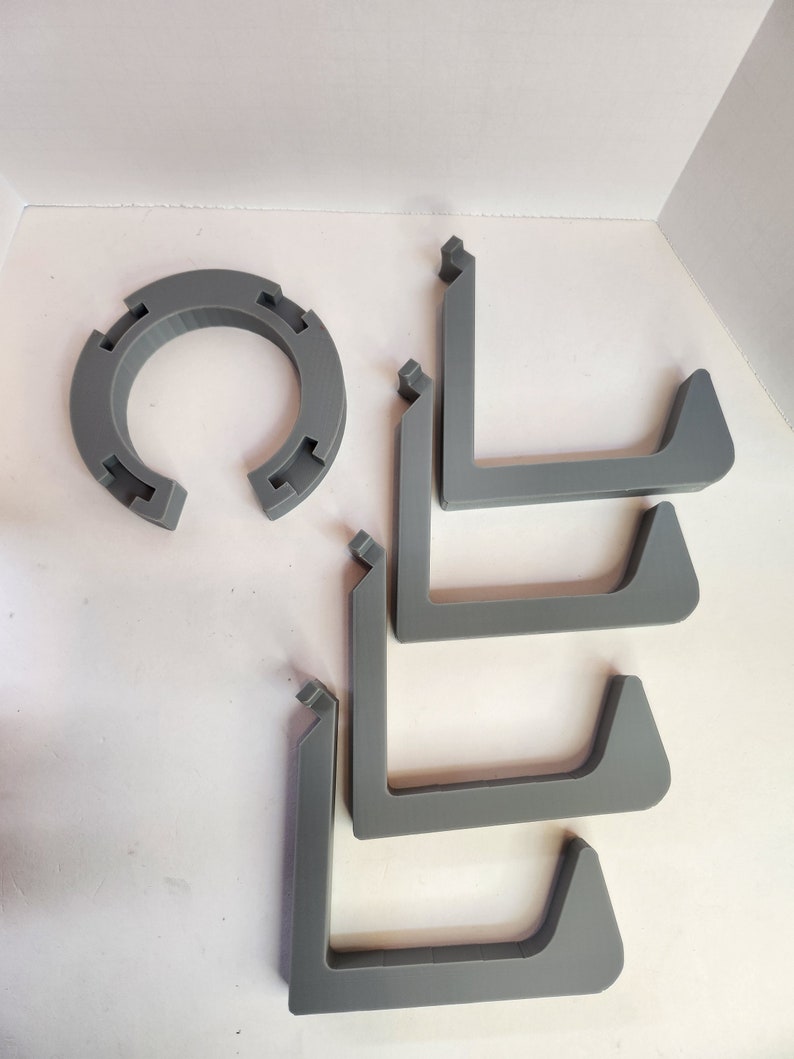 May include: Five gray plastic L-shaped shelf brackets and a gray plastic ring.