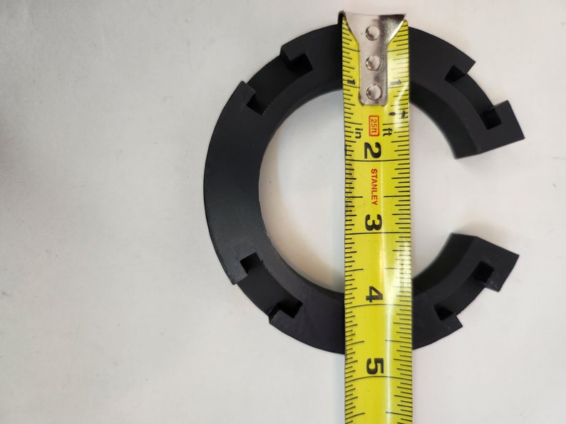 May include: A black plastic ring with a measurement tape showing it is 3 inches in diameter.