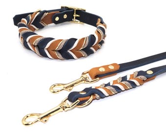 May include: A braided leather dog collar and leash set in navy blue, brown, and white with gold hardware.