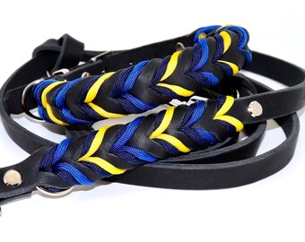 May include: Black leather dog leash with a braided blue and yellow paracord handle.