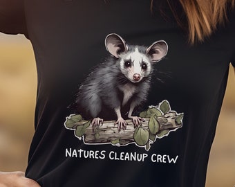 May include: A black t-shirt with a graphic of a possum sitting on a branch. The text "Natures Cleanup Crew" is printed below the possum.