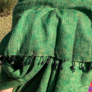 Peut inclure: Un châle vert avec des franges noires. Le châle est fait d'un matériau doux et duveteux et a un léger éclat.