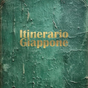 Può includere: Una copertina di libro verde usurata con il titolo "Itinerario Giappone" in lettere dorate.