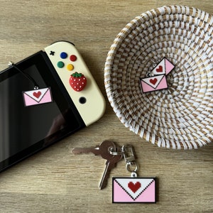 Colgante con forma de corazón de píxeles / Tapón antipolvo para Nintendo Switch / Pendientes colgantes ligeros de acero quirúrgico hipoalergénico / Llavero con forma de pinza de langosta