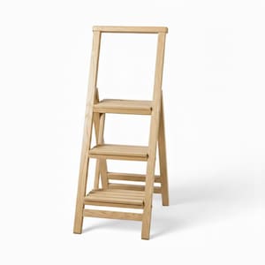 Könnte beinhalten: Eine hellfarbene Holztrittleiter mit drei Stufen und einem oberen Griff. Die Trittleiter ist aus Naturholz gefertigt und hat ein schlichtes, funktionales Design. Die Stufen sind etwa 30 cm breit.