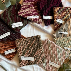 May include: Ten knitted squares in various color combinations, including orange and brown, peach and hunter green, mint and rose, green and peach, peach and grey, jazz stripe, purple and pink, purple and black, burgundy and hunter green, and burgundy and dark grey.
