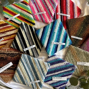 May include: A collection of 10 crocheted pot holders in various colors and patterns, including brown and tan, warm wheat, dark dove, frigid waters, soft sky, amethyst, citrus punch, grasses (speckled), pink punch, and pink sunset.