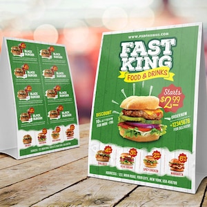 May include: A green and white table tent sign with the text "Fast King Food & Drinks" and a picture of a hamburger. The sign also includes the text "Starts £2.99" and "Order Now +12345678 for Delivery".
