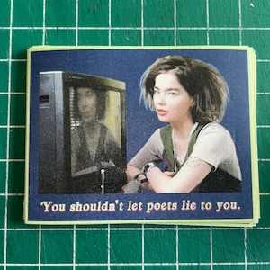 May include: A woman with dark hair sits in front of a television screen. The screen shows a blurry image of a person. The text "You shouldn't let poets lie to you." is printed below the image.