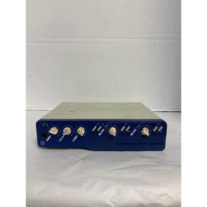 May include: A rectangular audio device with a blue front panel and a light gray top. The front panel features several knobs and input jacks. The device appears to be a piece of audio equipment, possibly a mixer or preamplifier.