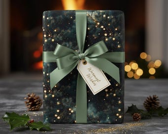 May include: A wrapped gift box with a dark teal and gold pattern, tied with a sage green ribbon and bow. A tag with the words "Warmest Wishes" hangs from the bow. Pine cones and holly sprigs are scattered around the gift.