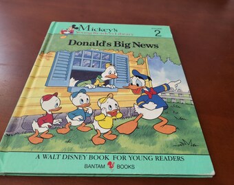 May include: A vintage copy of "Donald's Big News," Volume 2 from Mickey's Young Readers Library. The cover features Donald Duck and his nephews in a colorful illustration. The book is a Walt Disney book for young readers.