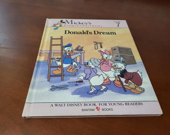 May include: A hardcover children's book titled "Donald's Dream" from the Mickey's Young Readers Library series. The cover features Donald Duck and other Disney characters in a colorful illustration. The book is a Walt Disney Book for Young Readers.