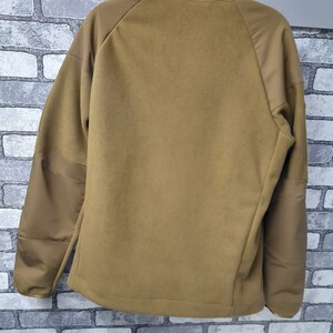 May include: A brown fleece jacket with a zip fastening and a stand-up collar. The jacket has a brown and tan colour block design.