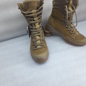 May include: A pair of brown leather hiking boots with a lace-up closure and a thick rubber sole. The boots have a high shaft and are made of a durable material.