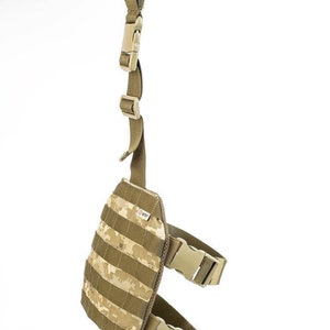 May include: A tan and brown camouflage tactical leg strap with adjustable buckles and a loop for attaching to a belt or other gear.