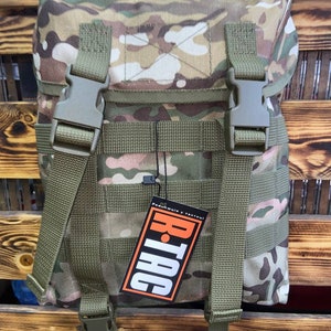 May include: A camouflage green tactical backpack with adjustable straps and a black tag that says "R-Tac" with the text "Рашник и такти" in Cyrillic script.