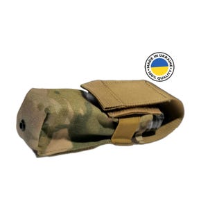 Peut inclure: Une pochette tactique de camouflage vert et beige avec une fermeture velcro et une sangle noire. La pochette est fabriquée en Ukraine et arbore un drapeau ukrainien bleu et jaune.