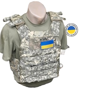May include: A tactical vest with a camouflage pattern and multiple pouches. The vest has a patch with the Ukrainian flag and the text "PTNPNX". The vest is labeled "Made in Ukraine, 100% Quality".