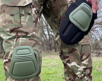 May include: Camouflage pants with green knee pads. The knee pads are attached to the pants with black straps.