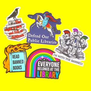 May include: A collection of colorful stickers with various designs and text on a yellow background. The stickers include a raven on books, a knight on a horse, squirrels reading books, a rainbow, and the phrases "Defend Our Public Libraries" and "Everyone Belongs at the Library."
