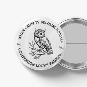 May include: A white button with a black and white illustration of an owl perched on a branch. The text around the owl reads "When cruelty becomes normal, compassion looks radical."