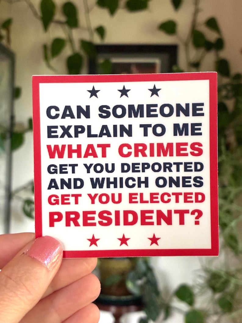 Op de afbeelding: Een witte sticker met een rode rand en de tekst: "CAN SOMEONE EXPLAIN TO ME WHAT CRIMES GET YOU DEPORTED AND WHICH ONES GET YOU ELECTED PRESIDENT?" De tekst is in zwart en rood met drie sterren aan de boven- en onderkant.