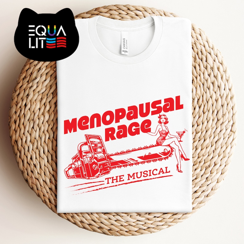 May include: White t-shirt with a red graphic of a woman sitting on a chainsaw with the text "Menopausal Rage - The Musical".