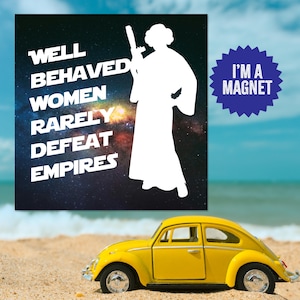 Puede incluir: Una silueta blanca de la princesa Leia sosteniendo un bláster contra un fondo de galaxia azul oscuro y púrpura. El texto "WELL BEHAVED WOMEN RARELY DEFEAT EMPIRES" está impreso en blanco en el lado izquierdo de la imagen. Un estallido de estrella azul con el texto "I'M A MAGNET" está en la esquina superior derecha de la imagen.