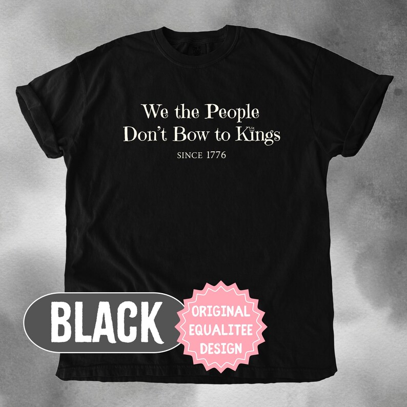 K&ouml;nnte beinhalten: Schwarzes T-Shirt mit dem wei&szlig;en Text "We the People Don't Bow to Kings" und "Since 1776". Das Shirt hat auch ein schwarzes Oval mit dem Wort "BLACK" und einen rosa Stern mit "ORIGINAL EQUALITEE DESIGN".