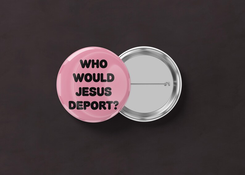 May include: A pink button with the text "WHO WOULD JESUS DEPORT?" in black. The button is next to a silver-colored button back with a pin.