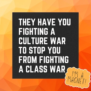 Könnte beinhalten: Ein schwarzer Magnet mit weißem Text: "THEY HAVE YOU FIGHTING A CULTURE WAR TO STOP YOU FROM FIGHTING A CLASS WAR." Eine orange Sprechblase mit "I'M A MAGNET!" auf einem orange-gelben geometrischen Hintergrund.