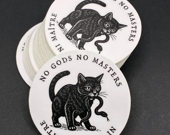May include: A stack of white, circular stickers with a black cat illustration. The cat is holding a snake in its mouth. The text "NO GODS NO MASTERS" and "NI DIEU NI MAÎTRE" is printed around the edge of the sticker.
