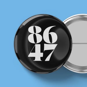 May include: A glossy black button with the numbers 86 and 47 in white. The button is round and has a shiny surface. The background is a solid light blue color.