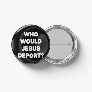 May include: A black button with the text "WHO WOULD JESUS DEPORT?" in white, next to a silver-colored button back. The button is round and glossy, with a pin on the back. The text is centered on the button.