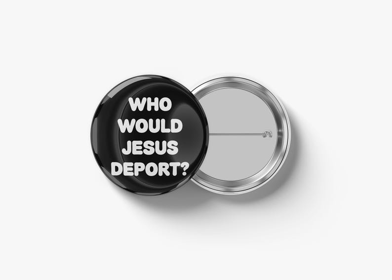 May include: A black button with the text "WHO WOULD JESUS DEPORT?" in white, next to a silver-colored button back. The button is round and glossy, with a pin on the back. The text is centered on the button.
