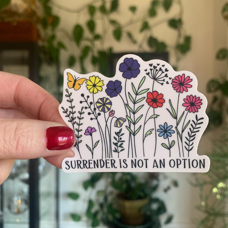 May include: A white sticker with a colourful floral design and the text "Surrender is not an option".