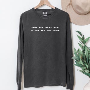 May include: A dark gray long-sleeve t-shirt with a white design of braille dots spelling out the word "love".