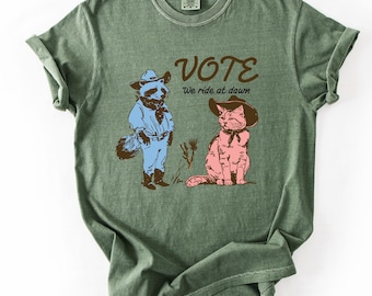 VOTE We Ride At Dawn Shirt & Sweatshirt, Cute Raccoon Cat Cowboy T-Shirt, Progressive Political Tee, Wild West Election Comfort Colors Top