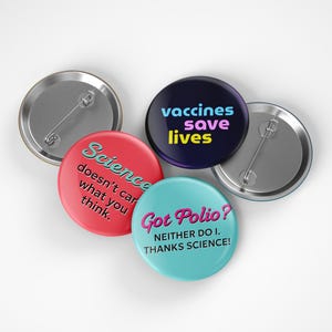 May include: A collection of round pinback buttons with various messages. One button reads "vaccines save lives" in colorful text on a dark blue background. Another says "Science doesn't care what you think." A third says "Got Polio? Neither do I. Thanks Science!"